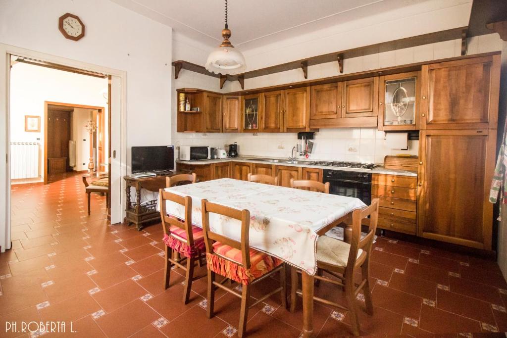 een keuken met een tafel en stoelen en een keuken met houten kasten bij Bussana Forever, Sanremo Est in Sanremo