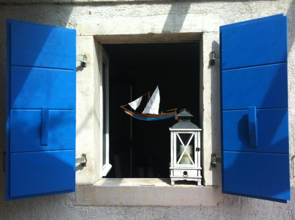 a window with a view of a sail boat in a room at House Ivas with garden in Zambratija