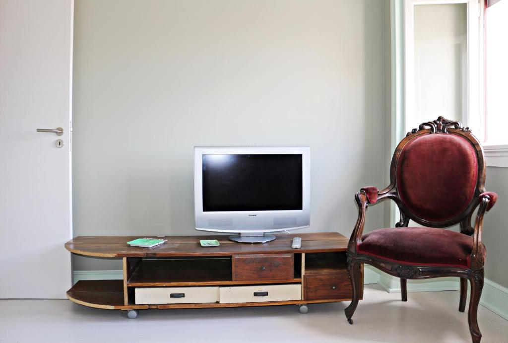 a room with a desk with a television and a chair at ARMAZÉM VILAÇA - Ap. Lavoisier in Coimbra