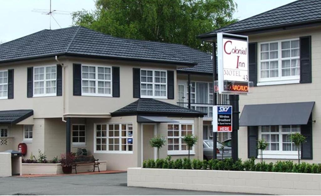 un edificio con una señal delante de él en Colonial Inn Motel, en Christchurch