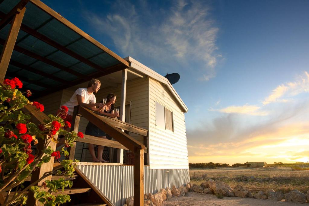 a man and woman standing on the porch of a tiny house at Coodlie Park Eco Retreat in Talia