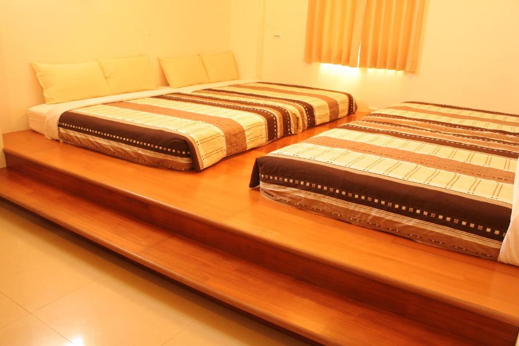 Duas camas sentadas num balcão de madeira num quarto em Long Beach Private Lodging em Magong