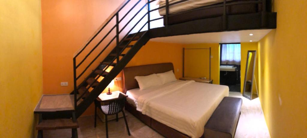 a bedroom with a bed and a spiral staircase at The Wharf in Semporna