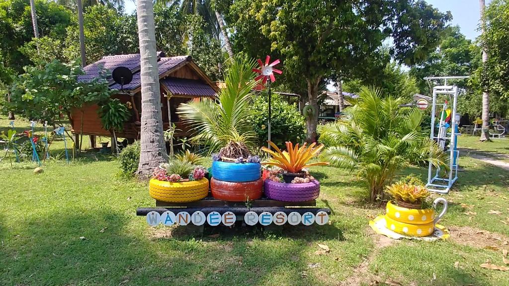 a group of potted plants in colorful baskets in a yard at Wandee Resort Bankrut in Ban Krut