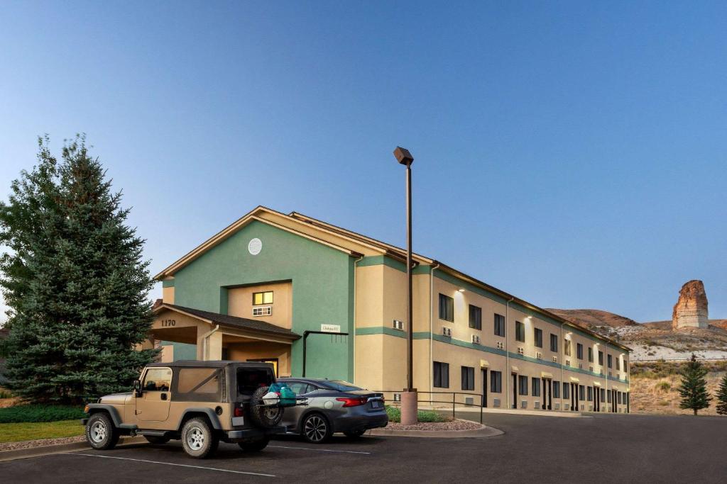 a building with a truck parked in a parking lot at Travelodge by Wyndham Green River WY in Green River