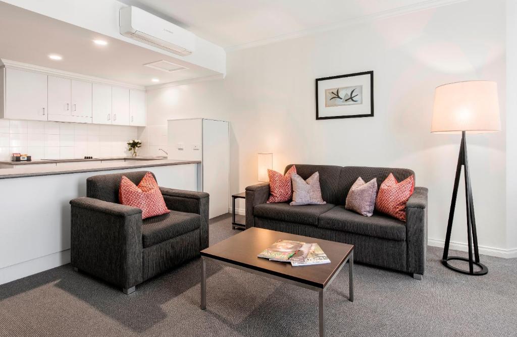 a living room with two couches and a coffee table at Franklin Apartments in Adelaide