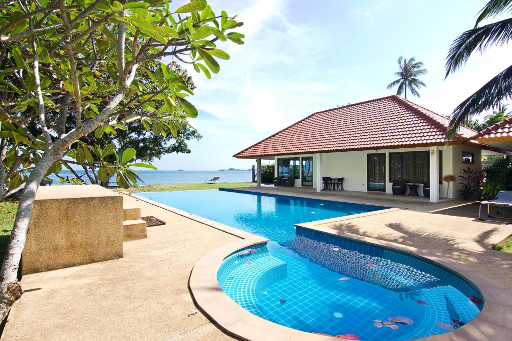 a swimming pool in front of a house at Heaven Beach Koh Samui in Laem Sor