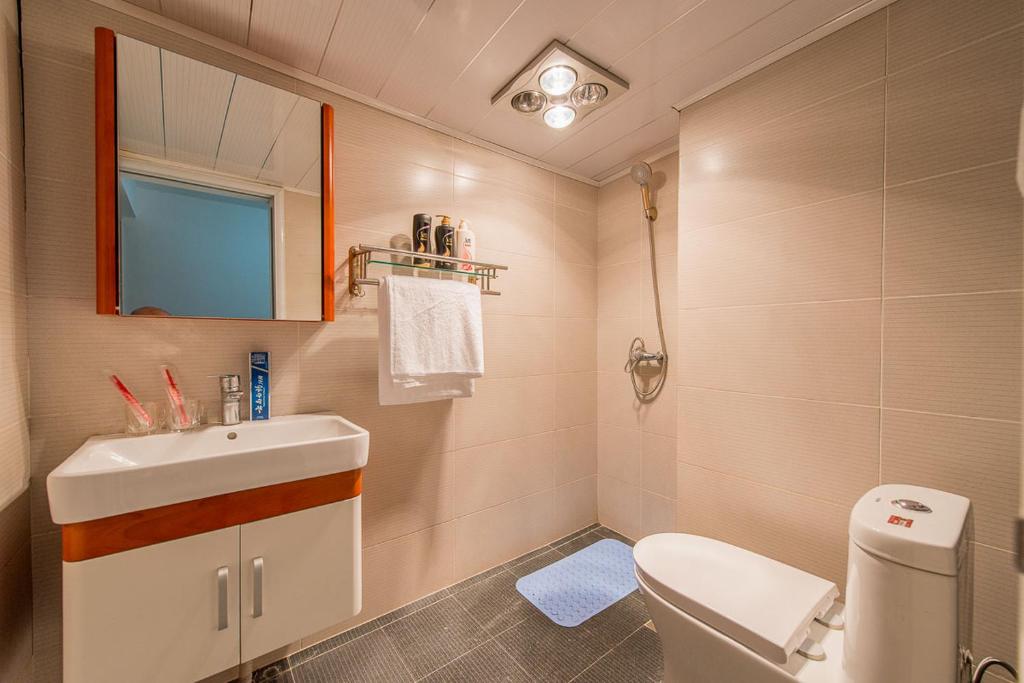 a bathroom with a sink and a toilet and a mirror at Xi'an Yanta·Shaanxi History Museum· Locals Apartment 00122350 in Xi'an