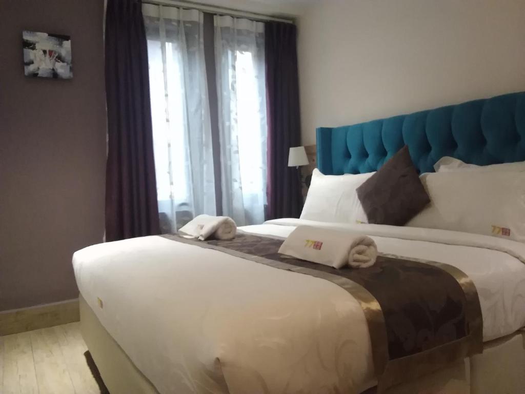 Schlafzimmer mit einem großen Bett mit blauem Kopfteil in der Unterkunft 77 Boutique Hotel in Kuala Lumpur