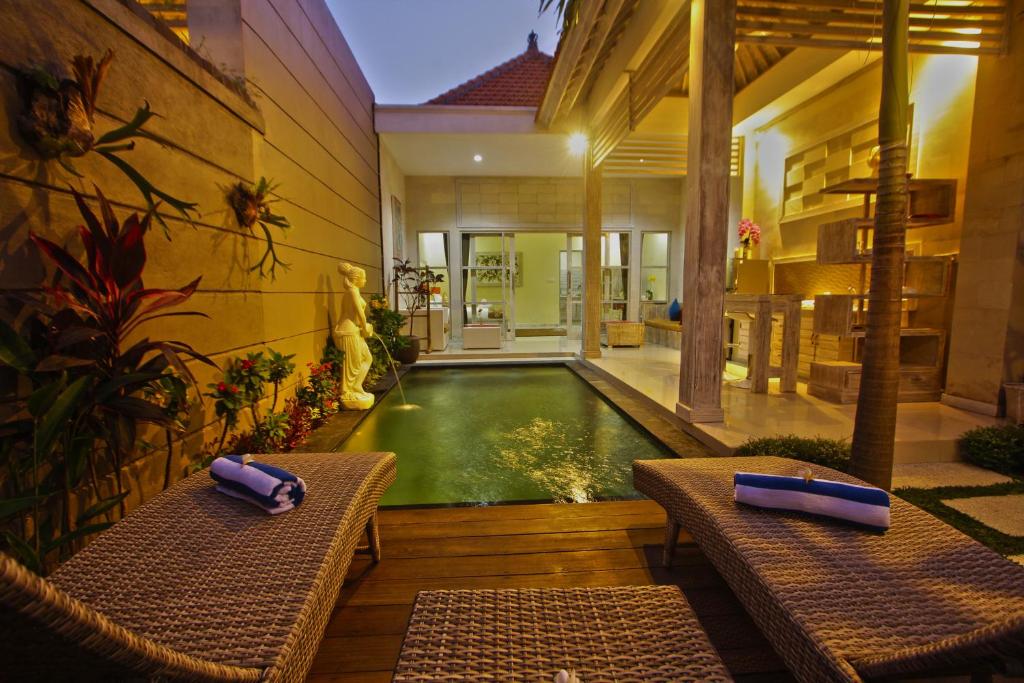 basen w środku domu z dwoma ławkami w obiekcie Sri Permana Suite and Villa Ubud w mieście Ubud