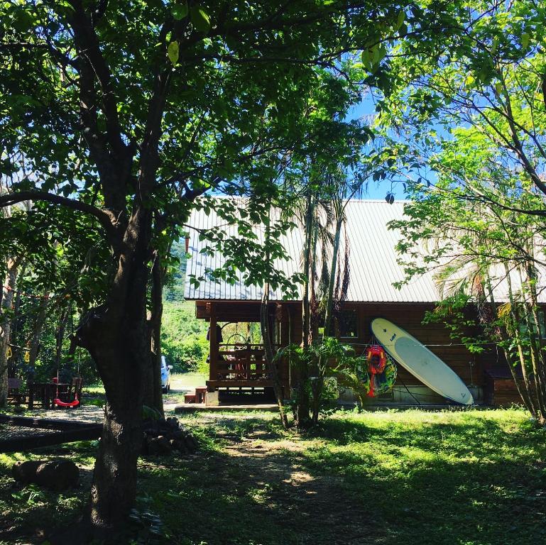 a surfboard sitting on the grass next to a house at YOISAMA Sunrise Beach House in Ishigaki Island