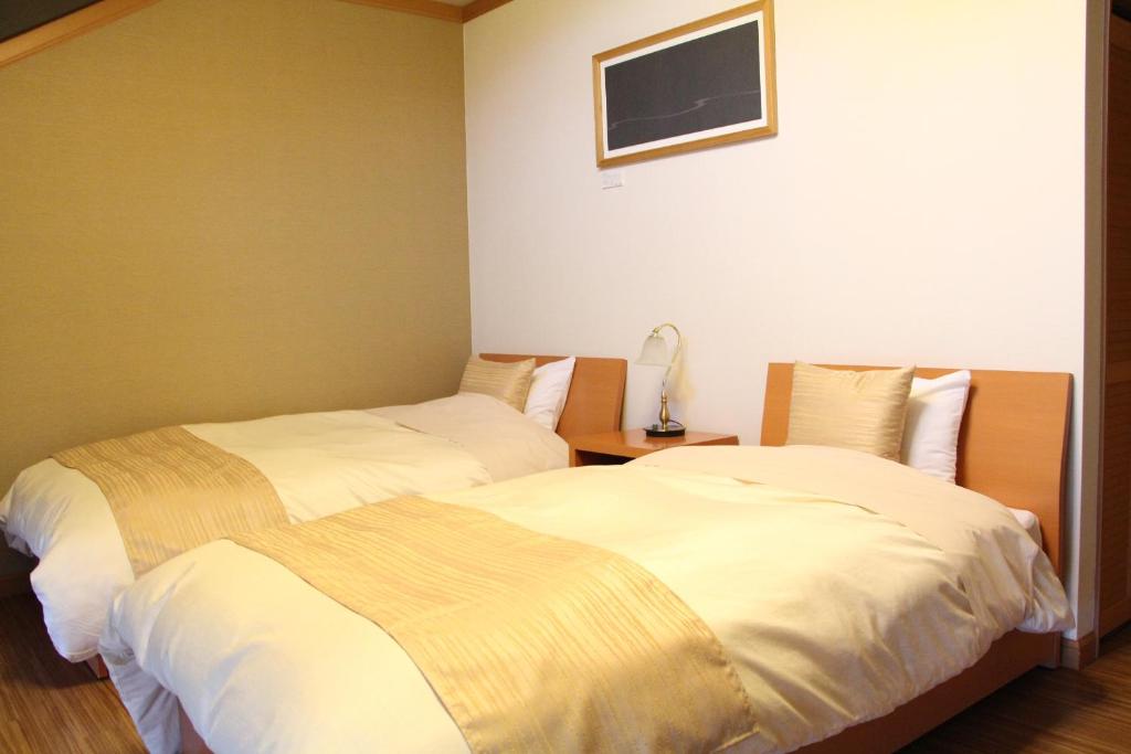 Postel nebo postele na pokoji v ubytování Maruyama Onsen Kojyokan