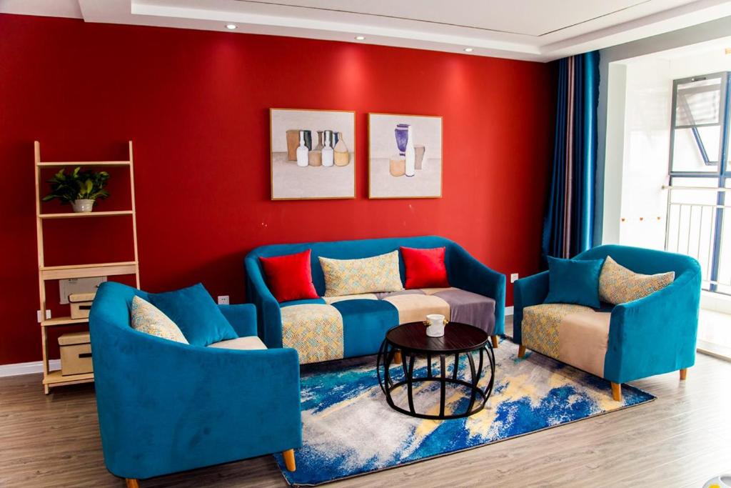 a living room with blue couches and a red wall at Taian·Taishan·Mount Tai Scenic Spot· Locals Apartment 00123250 in Tai'an