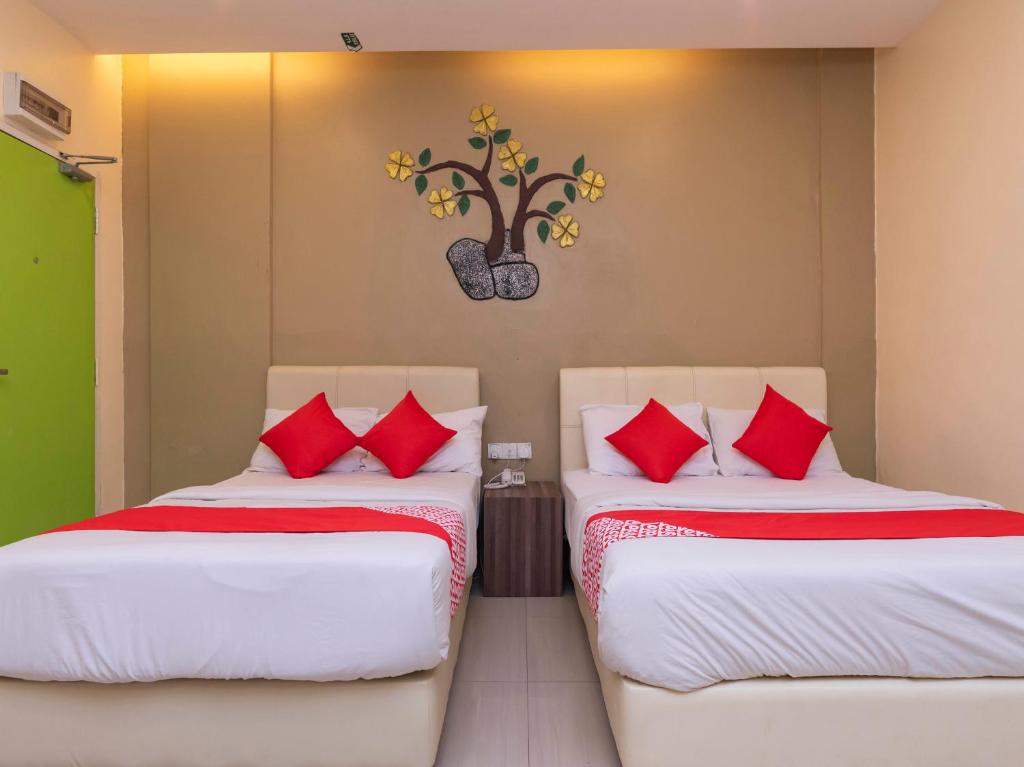two beds with red pillows in a room at I Leaf Boutique Hotel in Johor Bahru