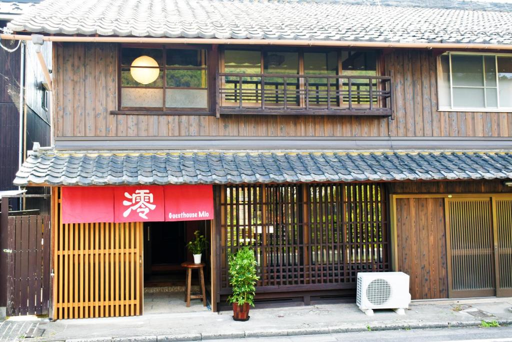 un edificio con un cartello sulla parte anteriore di Guesthouse Mio a Omihachiman
