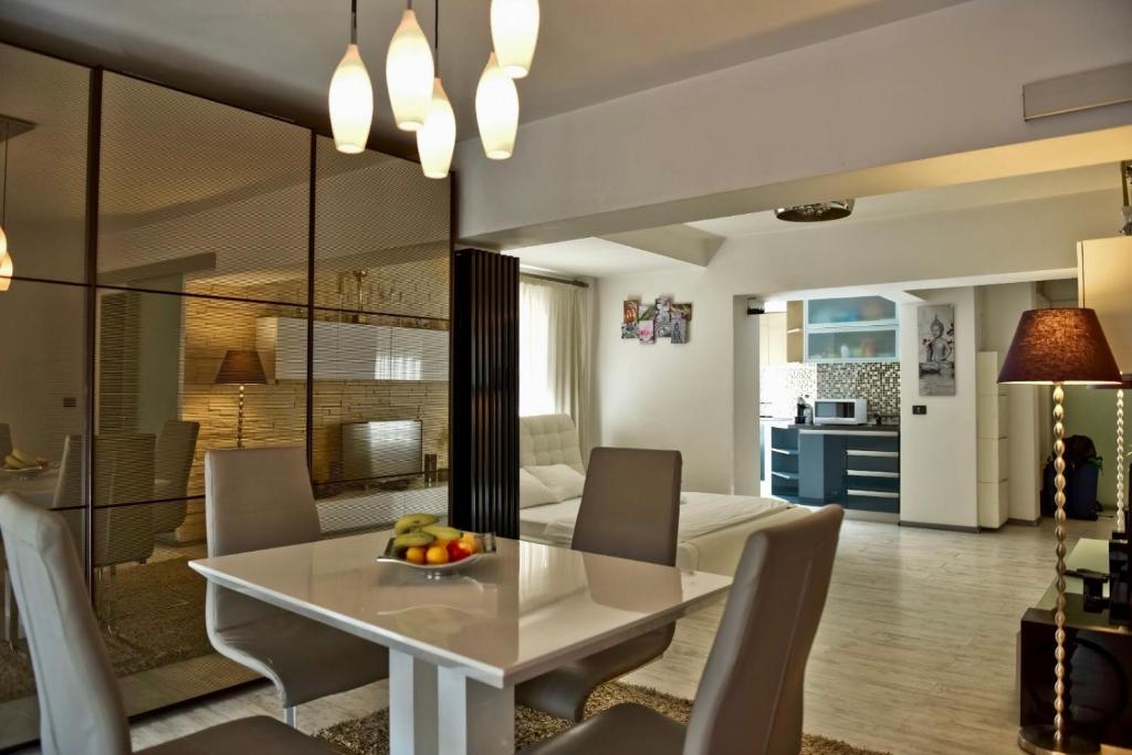 comedor y sala de estar con mesa blanca y sillas en Eric Apartment 100, en Bucarest