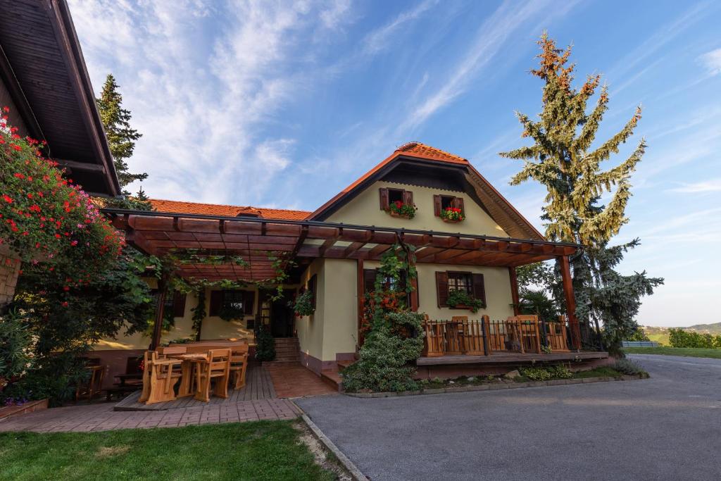 uma casa com um alpendre com uma mesa e cadeiras em Turistična Kmetija Pungračič em Zavrč