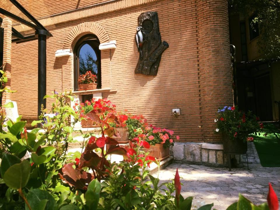 budynek z kwiatami i oknem w obiekcie LH Albergo il Picchio w mieście Pescasseroli