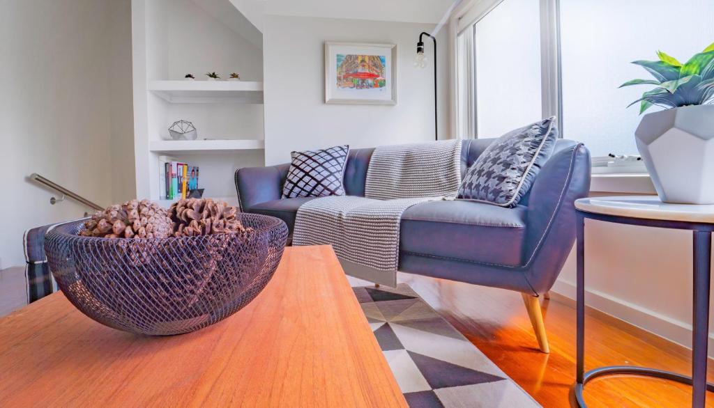 een woonkamer met een blauwe bank en een tafel bij Bayview Loft in Williamstown