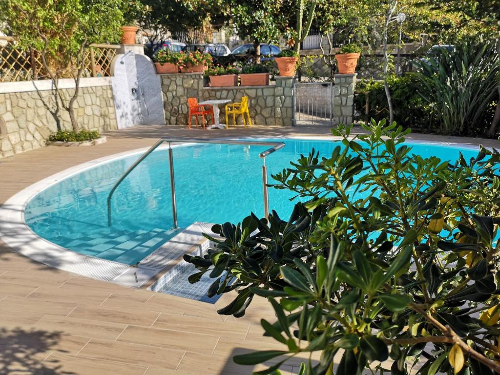a swimming pool in a yard with a table and chairs at Aparthotel Villa Marinù in Ischia