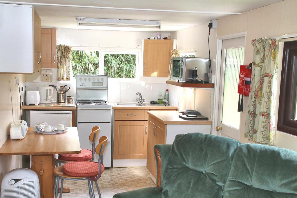 a kitchen with a couch and a table in a room at The Chalet at Mellowvean in St. Agnes 