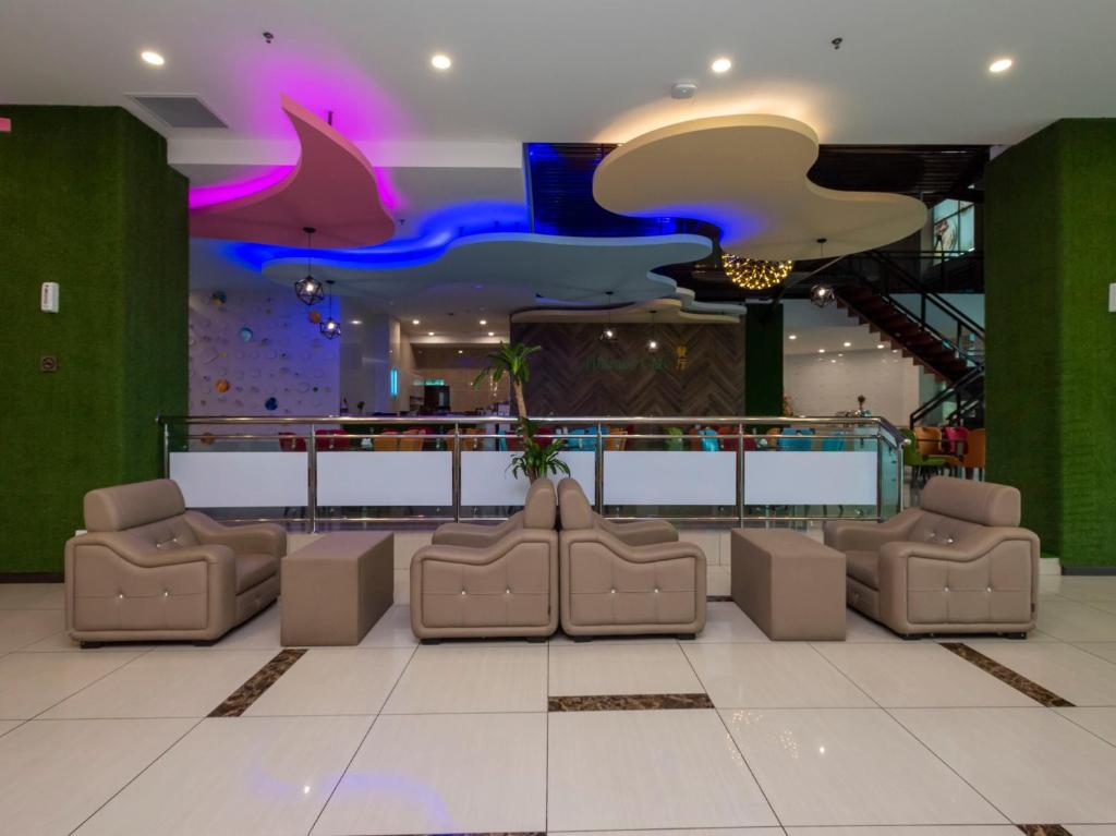 a lobby with a waiting area with couches and sharks on the ceiling at Hotel Holmes Gp in Nusajaya
