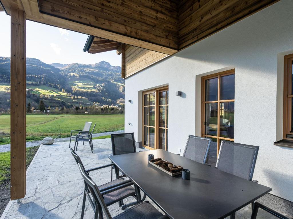 a table and chairs on a patio with a view at Chalet with garden in Bad Hofgastein Salzburg in Bad Hofgastein