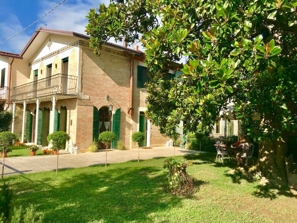 uma grande casa de tijolos com uma árvore em frente em Maison Elena em Mirano