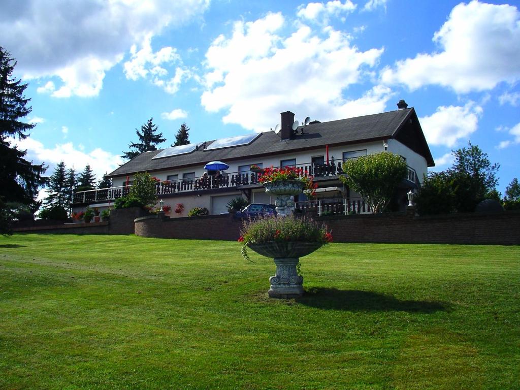 a house with a planter in the middle of a yard at Apartment " Welwerwoltz " in Wilwerwiltz