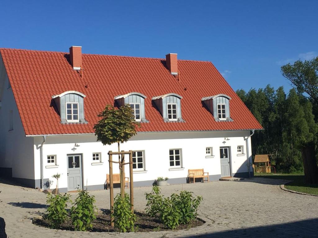 ein großes weißes Haus mit orangefarbenem Dach in der Unterkunft Hof Vilmnitz Haus B in Putbus