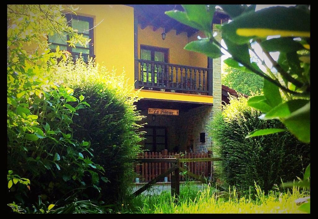 żółty dom z balkonem na górze w obiekcie La Prestosa w mieście Arriondas