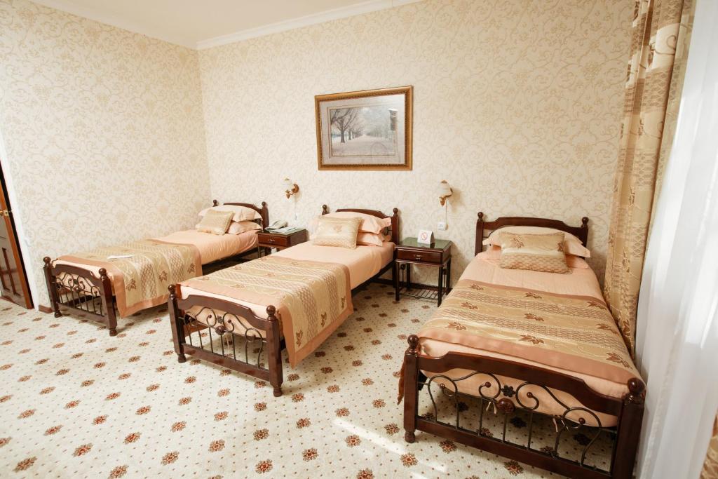 a bedroom with three beds in a room at Hotel Asia Khiva in Khiva