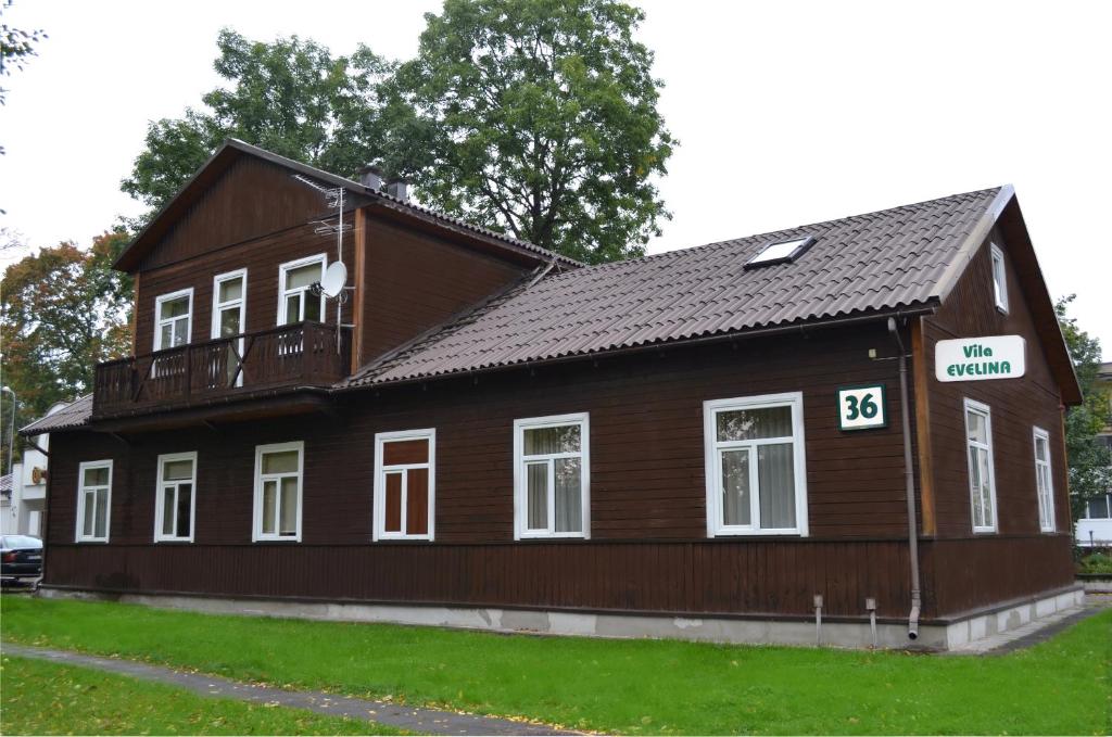 Casa marrón con balcón en la parte superior. en Vila Evelina, en Druskininkai