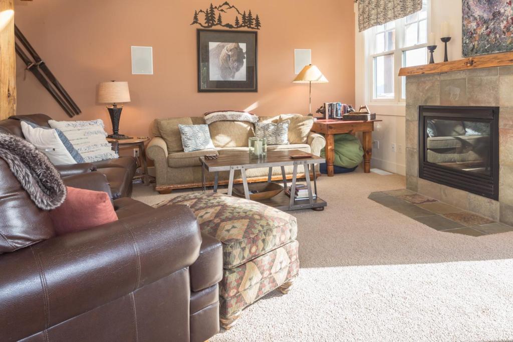 a living room with a couch and a fireplace at Saddle Ridge Townhome | Unit J1 in Big Sky