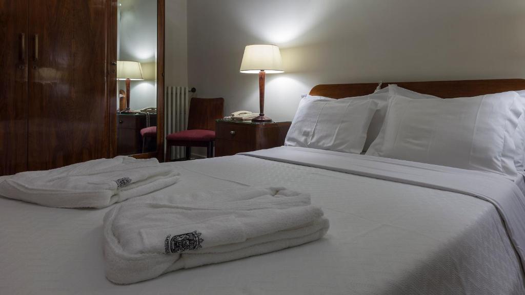 a hotel room with two towels on a bed at Hotel Astoria in Coimbra