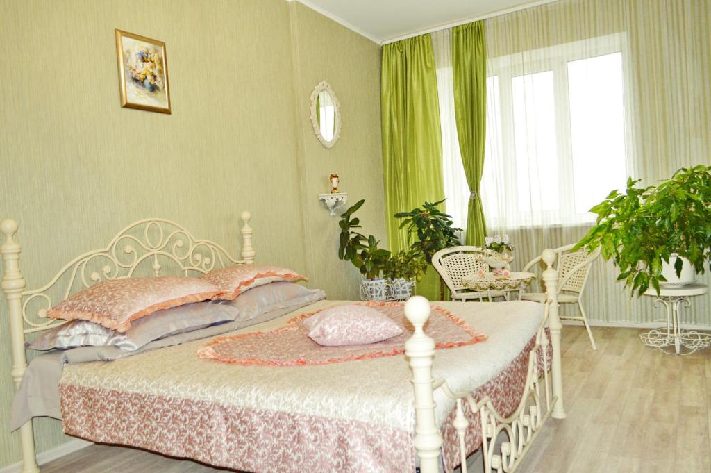 クルスクにあるGarmoniya Apartmentのベッドルーム(ピンクの枕が付いた白いベッド付)