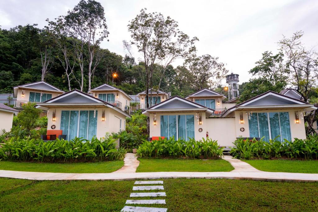 a row of houses with blue doors on a lawn at Krabi Home Resort in Tab Kaek Beach