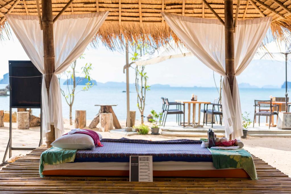 a bed in a tent with the beach in the background at Krabi Home Resort in Tab Kaek Beach