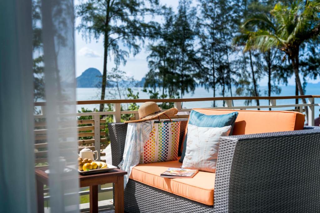 an orange couch sitting on a porch with a table at Krabi Home Resort in Tab Kaek Beach