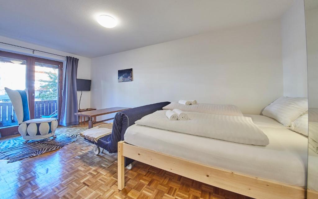 a bedroom with a bed and a desk and a window at Appartement Comfy in Saalbach Hinterglemm