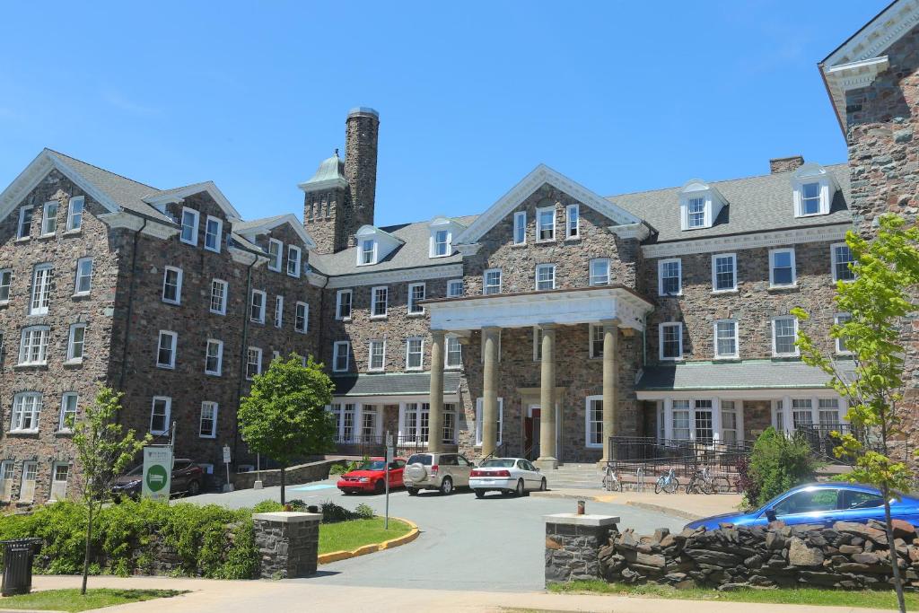 a large brick building with cars parked in a parking lot at Dalhousie University in Halifax