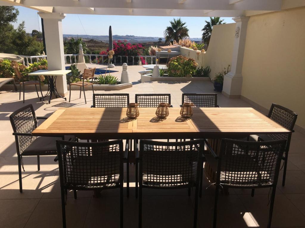 ein Holztisch und Stühle auf einer Terrasse in der Unterkunft Villa Ponte Vista in Castro Marim