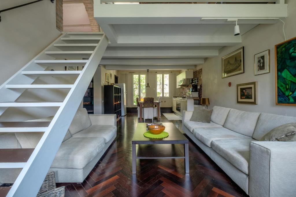 a living room with a couch and a staircase at Attico Terrazza in Venice
