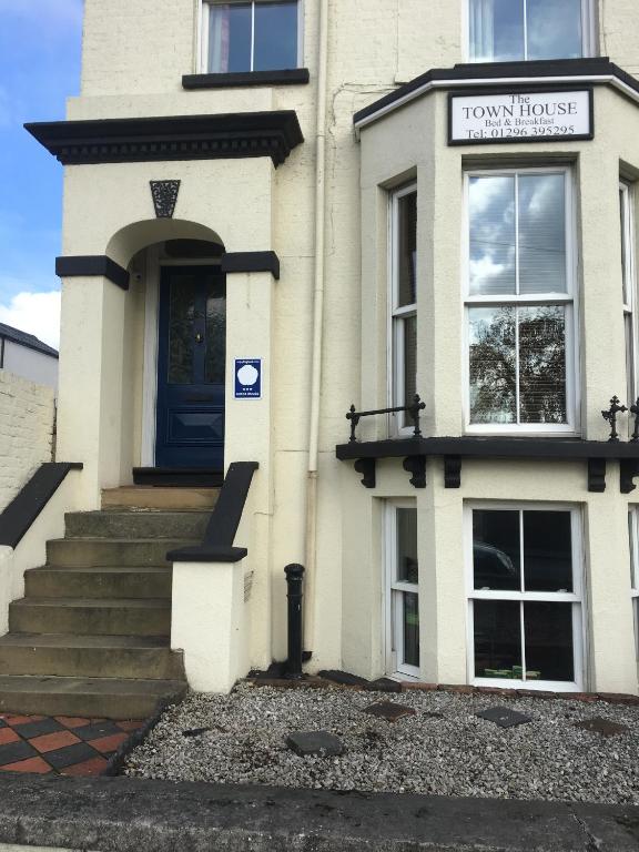 a white building with a sign on the front of it at The Townhouse B and B free continental breakfast included in Aylesbury