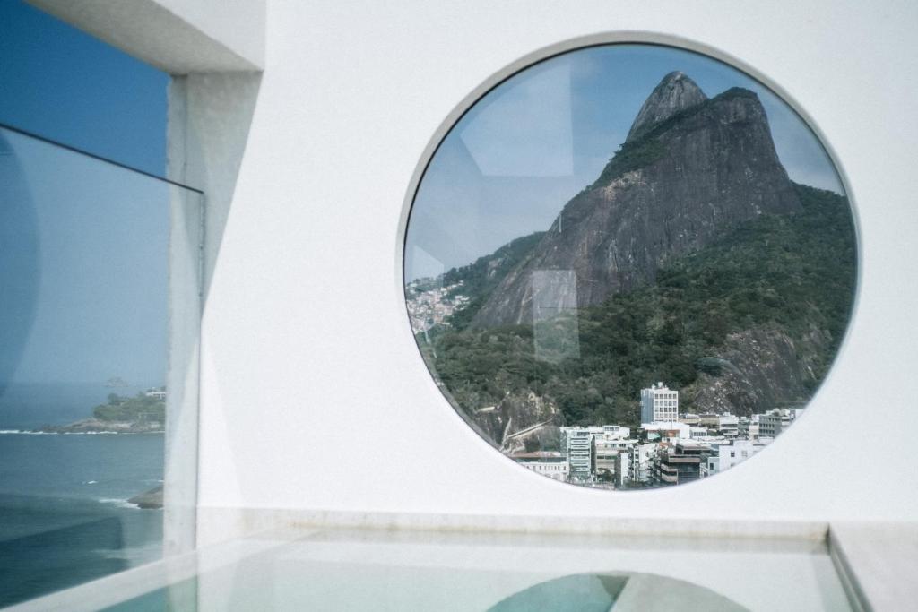 uma janela redonda com vista para a montanha em JANEIRO Hotel no Rio de Janeiro