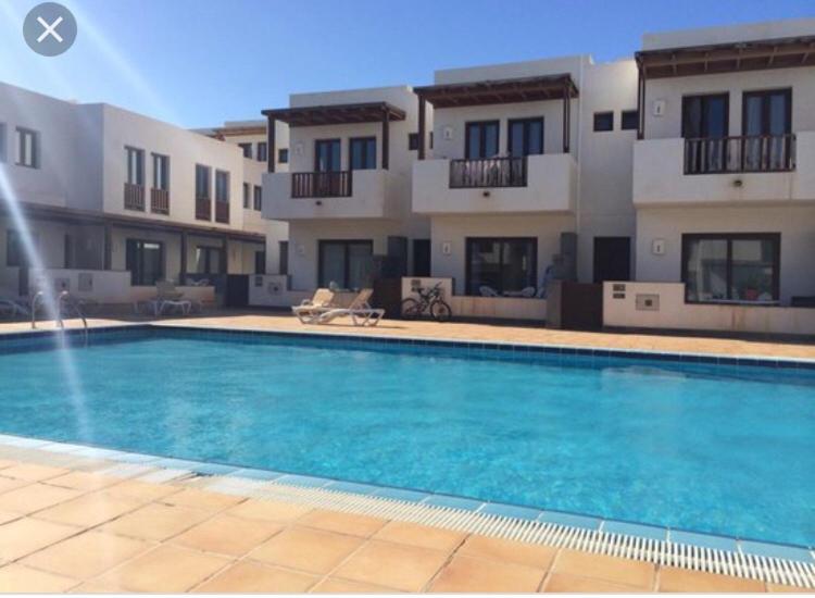 a large swimming pool in front of a building at Noray Swan Duplex right at the Pool in Puerto Calero