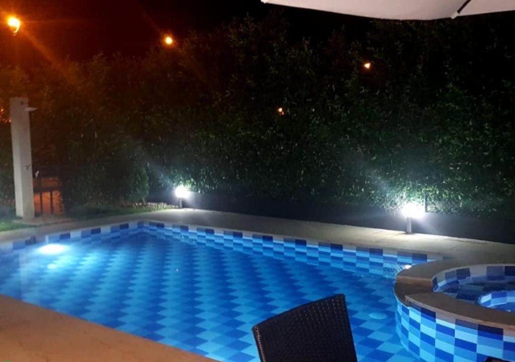 una gran piscina por la noche con luces azules en Casa Quinta familiar piscina privada Girardot, en Girardot