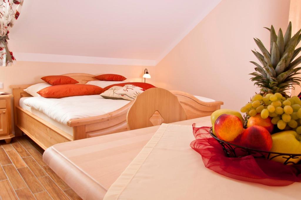 a hotel room with two beds and a bowl of fruit at Pension Weindl in Notzing