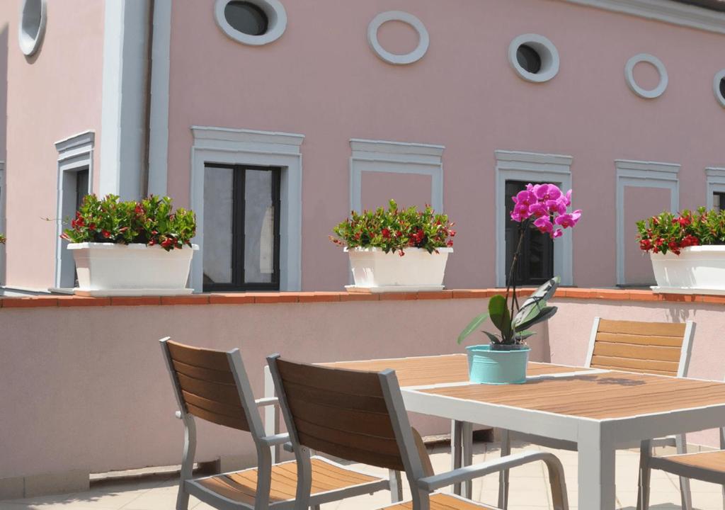 une table et des chaises sur une terrasse avec des plantes en pot dans l'établissement Timone 31, à Civitanova Marche