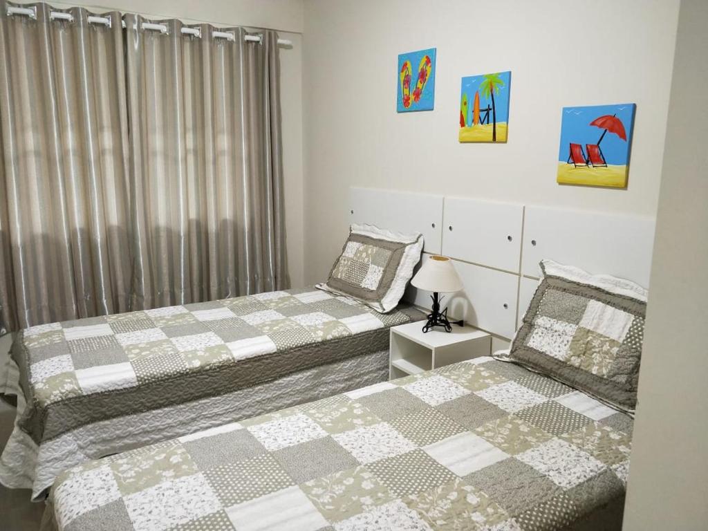 two beds sitting next to each other in a bedroom at Don Rafael 02 dormitórios, 80m mar, Mariscal in Bombinhas